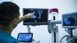Clinician pointing at a mammography on a screen